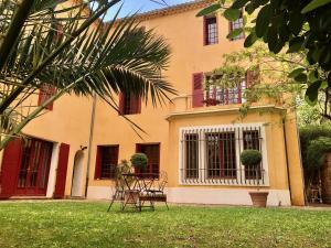 um edifício com cadeiras em frente a um quintal em B&B Villa Roumanille em Aix-en-Provence