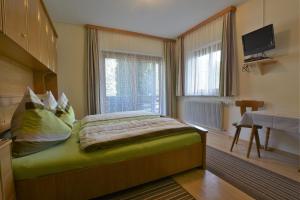 um quarto com uma cama e uma televisão em Pension Liesertalerhof em Trebesing