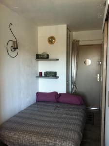 Cama en habitación con colcha púrpura en VACANCES MER, en Saint-Cyr-sur-Mer