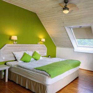 BELYSIUM Bed & Breakfast Panzió في جينيسدياس: غرفة نوم بسرير مع جدران خضراء وسقف