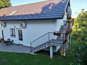 a white house with a staircase and a patio at New apartment near Plitvice lakes in Smoljanac