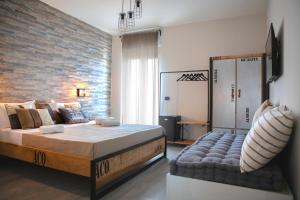 1 dormitorio con 1 cama grande y pared de ladrillo en Urban Bed and Breakfast, en Ugento