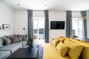 ein Wohnzimmer mit einer Couch und einem Tisch in der Unterkunft Cavtat Old School in Cavtat