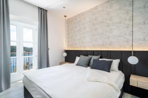 ein Schlafzimmer mit einem großen weißen Bett mit blauen Kissen in der Unterkunft Cavtat Old School in Cavtat + 37 Fotos