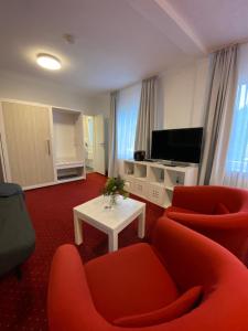 a living room with two chairs and a tv at Hotel Pension Haus Talblick Edersee in Hemfurth-Edersee