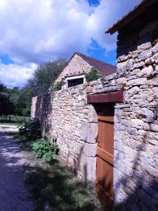 an old stone building with a gate and a stone wall at Le Nid d'été in Montcléra