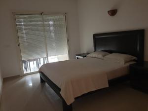 席迪拉罕的住宿－Appartement Ola Blanca 2，一间卧室设有一张大床和一个大窗户