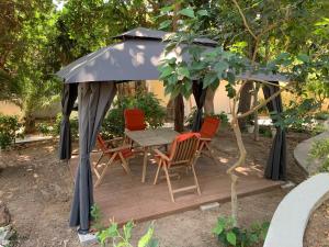 a gazebo with a table and chairs under it at A&B Rhodes city apartments in Rhodes Town