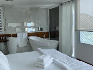 baño blanco con bañera y lavamanos en The Black Palm, en Philipsburg