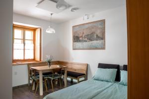 a bedroom with a bed and a table and a dining room at Apartmaji Utrinek, apartma Salon in Podbrdo