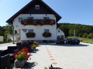 une maison blanche avec des fleurs sur son côté dans l'établissement House Pox, aux lacs de Plitvice