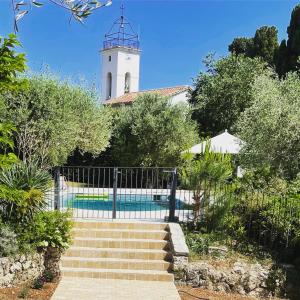 ein Gebäude mit einem Turm und einer Treppe mit einem Leuchtturm in der Unterkunft Villa La Carpenée in Roquefort-les-Pins