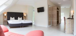 a bedroom with a bed and a tv on a wall at Landhotel Weihermühle in Thaleischweiler-Fröschen