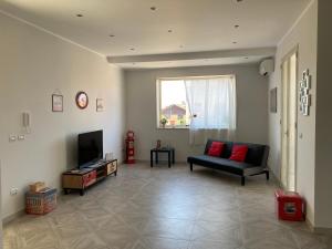 - un salon avec un canapé et une télévision dans l'établissement Apartment 1st floor in Villino Eliana, à Priolo Gargallo