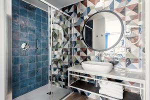 bagno con lavandino e specchio di Tuscany Hotel Alle Dune a Marina di Castagneto Carducci