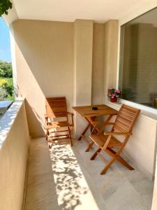 balcón con 2 sillas, mesa y ventana en Magnolia apartment en Varna