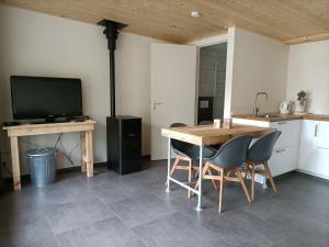 a kitchen with a table and chairs and a television at Het Denneke in Veldhoven