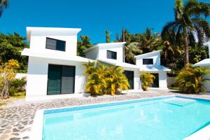 une maison blanche avec une piscine en face de celle-ci dans l'établissement Residence Las Dos Palmas, à Las Terrenas