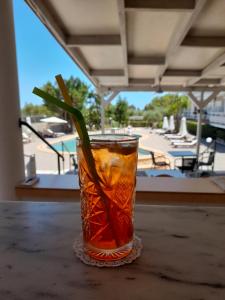 a drink sitting on a table next to a pool at En Armonia Hotel in Laganas