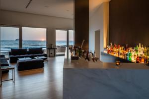 een woonkamer met een bar met uitzicht op de oceaan bij Hotel Punta Tipa in Trapani