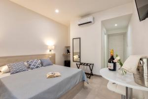 Un dormitorio con una cama y una mesa con una botella de vino en Atteros en Alguer