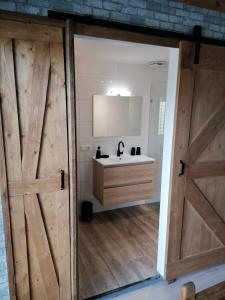 a bathroom with a wooden door and a sink at Park aan Zee in Vlissingen