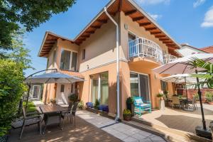 ein Haus mit einer Terrasse mit Tischen und Stühlen in der Unterkunft Villa Frida in Siófok