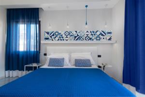a bedroom with a blue bed with blue curtains at Hotel Leone in Sorrento +37 photos