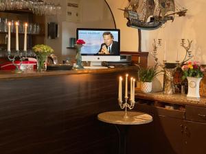 eine Bar mit einem TV auf einer Theke mit Kerzen in der Unterkunft The Burgklause Boutique Hotel in Linz am Rhein