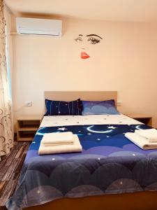 - une chambre avec un lit bleu et une femme sur le mur dans l'établissement Home for you, à Eşelniţa