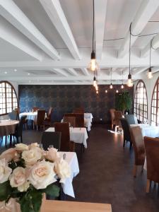 a dining room with tables and chairs and flowers at L'Auberge in Saint-Viance