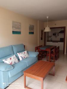 - un salon avec un canapé bleu et une table dans l'établissement APARTAMENTO RONDA 4 BOLICHES Primera línea de playa, à Fuengirola