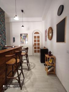 um quarto com um bar com cadeiras e uma televisão em Green House em Avola
