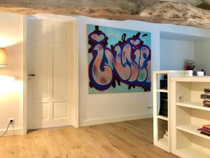 una habitación con una pintura en la pared en Chambres d'hôtes Vers la Croix, en Leynes