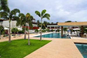 a swimming pool with palm trees and a resort at ILE DE PIPA LUXO in Pipa