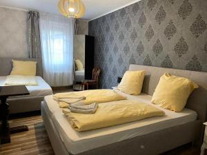 a bedroom with two beds with yellow sheets at The Burgklause Boutique Hotel in Linz am Rhein