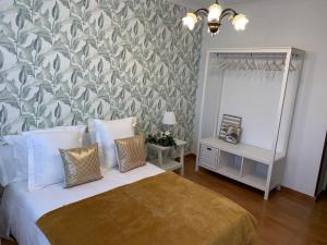 a bedroom with a bed with a green and white wallpaper at Falda do Pedroso in Santiago de Compostela