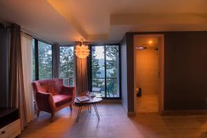 uma sala de estar com uma cadeira, uma mesa e uma janela em The Cloud Xpress em Nathia Gali