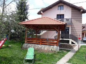 a gazebo in front of a house with a playground at Zlatiborska seoska idila in Zlatibor