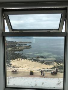 a view of a beach from a window at On The Prom in Portstewart