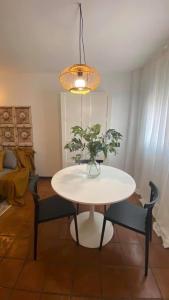 a white table with chairs and a vase with a plant at Casa Luz del Rocío Refugio con alma a 8 minutos de la Ermita in El Rocío +28 photos