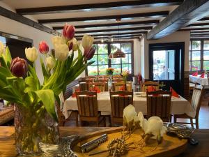 a dining room with a table with flowers in a vase at The Burgklause Boutique Hotel in Linz am Rhein