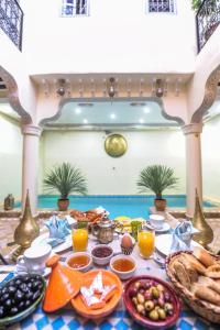 einen Frühstückstisch mit Speisen und Getränken auf dem Tisch in der Unterkunft Riad Milouda in Marrakesch