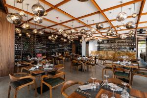 a restaurant with wooden tables and chairs and wine racks at Chic Boutique Hotel Vlore in Vlorë