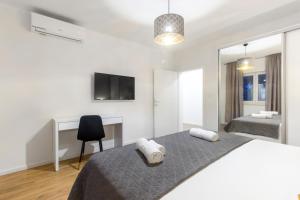 ein Schlafzimmer mit zwei Betten, einem Schreibtisch und einem Fernseher in der Unterkunft Villa Antonia with heated pool in Dograde + 31 Fotos