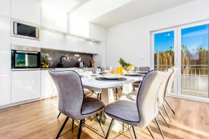 ein Esszimmer mit einem weißen Tisch und Stühlen in der Unterkunft Villa Antonia with heated pool in Dograde