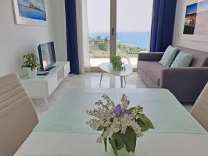 una sala de estar con una mesa con flores. en Breathtaking sea views apartment with private terrace 146 en Benidorm