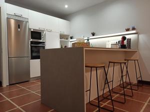 cocina con encimera y barra con taburetes en Pagés en Sant Climent Sescebes