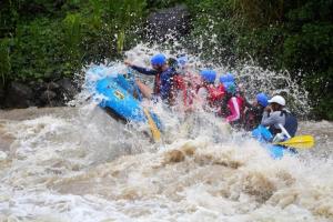 a group of people in a raft in a river at Hostal y cabinas anita-and rafting tour! in Siquirres