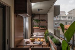 uma varanda com uma mesa e cadeiras e um sofá em The Blossom-Premium living residence at Heraklion em Heraclião